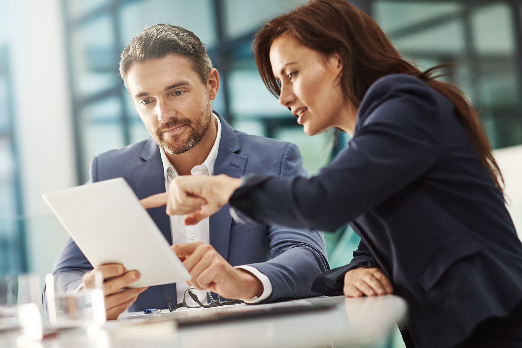 Two people looking over paperwork together in a work setting.
