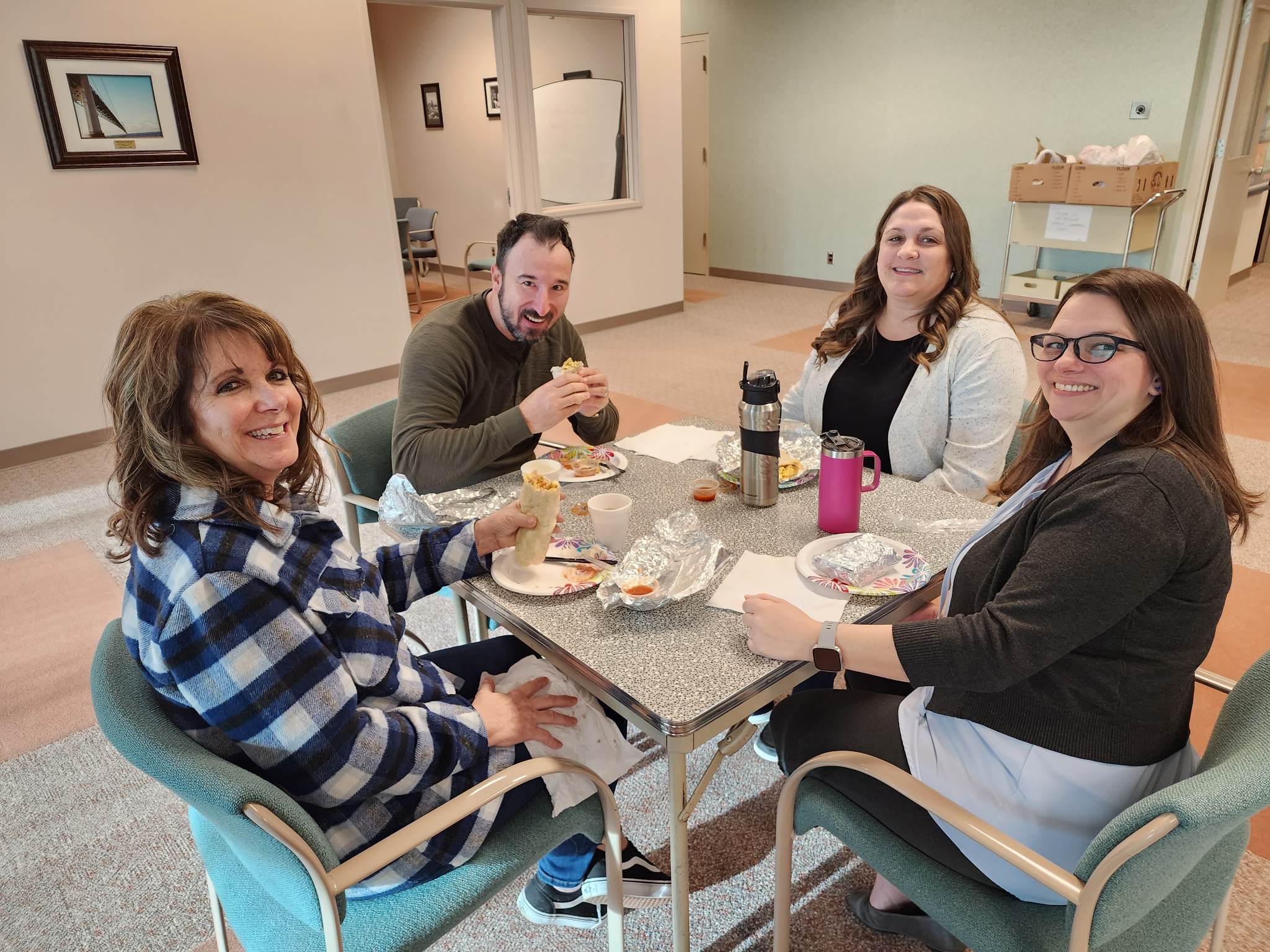 Four employees sitting around a square table.